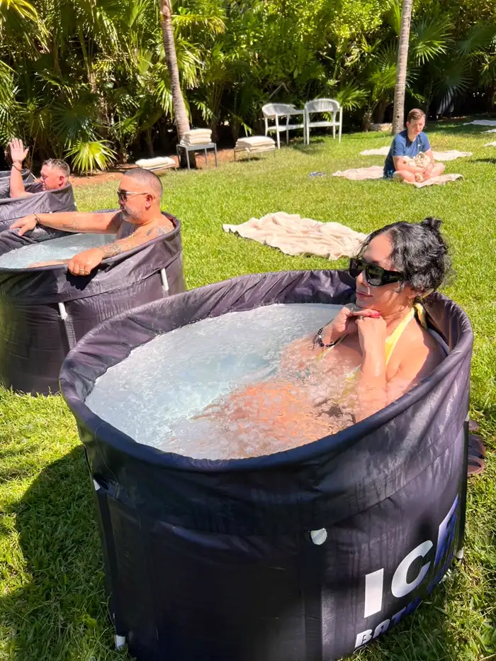 Una huésped dentro de la tina con la barbilla levantada, respirando, con el agua con hielo hasta el pecho